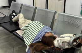 Chinese tourist reclining in waiting area in a Police Station.