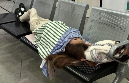 Chinese tourist reclining in waiting area in a Police Station.