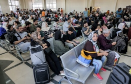 People sit in the waiting area at the Rafah border crossing in the southern Gaza Strip before crossing into Egypt on November 1, 2023. Scores of foreign passport holders trapped in Gaza started leaving the war-torn Palestinian territory on November 1 when the Rafah crossing to Egypt was opened up for the first time since the October 7 Hamas attacks on Israel, according to AFP correspondents. -- Photo: Mohammed Abed / AFP
