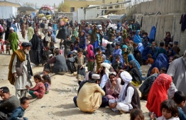 In this photo taken on November 1, 2023, Afghan refugees wait near a registration centre upon their arrival from Pakistan, at the Afghanistan-Pakistan border in the Spin Boldak district of Kandahar province. More than 165,000 Afghans have fled Pakistan in the month since its government ordered 1.7 million people to leave or face arrest and deportation, officials said on November 2. -- Photo: Sanaullah Seiam / AFP