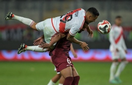 Peru's midfielder Yoshimar Yotun (Top) fights for the ball with Venezuela's midfielder Yangel Herrera during the 2026 FIFA World Cup South American qualification football match between Peru and Venezuela at the National Stadium in Lima on November 21, 2023. -- Photo: Ernesto Benavides / AFP