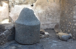 This handout picture released on December 8, 2023 by the Pompeii archaeological park, shows the remains of a mill in the Regio IX area of the site where a prison-bakery has been discovered, announced the archaeological park on the same day. According to historians the bakery was a space where enslaved people and donkeys were confined and exploited to grind the grain needed to make bread. A cramped room with no outside view, with small windows with iron gratings for the passage of light. And in the floor carvings to coordinate the movement of the animals, forced to walk around for hours with blindfolds on. -- Photo by Handout: Pompeii Archeological Park / AFP