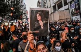 (FILES) A protester holds a portrait of Mahsa Amini during a demonstration in support of Amini, a young Iranian woman who died after being arrested in Tehran by the Islamic Republic's morality police, on Istiklal avenue in Istanbul on September 20, 2022. The family of Mahsa Amini, the Iranian Kurdish woman who died in custody, have been banned from travelling to France to collect a top rights prize awarded posthumously, their lawyer said on December 9, 2023. Amini died aged 22 on September 16, 2022, while being held by Iran's religious police for allegedly breaching the Islamic republic's strict dress code for women. -- Photo: Ozan Kose / AFP