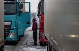 A Ukrainian truck driver is seen next to Ukrainian trucks on the parking lot near Korczowa Polish-Ukrainian border crossing, on December 5, 2023. In a Polish car park near the Ukrainian border, truck drivers stranded by a month-long blockade that has caused disruption and a row with Ukraine shoveled snow off their vehicles.
Around 100 truckers have been stuck in Korczowa, one of the crossings blocked by protesting Polish hauliers who complain about what they say is unfair competition from Ukrainian companies. -- Photo: Wojtek Radwanski / AFP