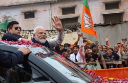This handout photograph taken on December 30, 2023 and released by Indian Press Information Bureau (PIB) shows India's Prime Minister Narendra Modi (2L) greeting people during a roadshow in Ayodhya. -- Photo: PIB / AFP