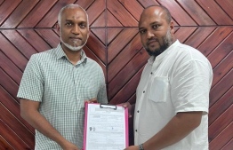 Newly elected Male' City Councilor Ahmed Rishwan hands over PNC membership form to President Dr Muizzu.-- Photo: PPM