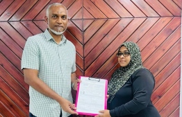 Councilor Nazima hands over her application form to the President.