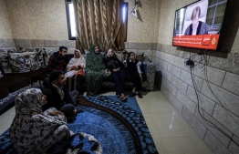 Members of a Palestinian family watch on a television set, the UN's top court in the Hague reading its initial decision in a case accusing Israel of genocide, in Rafah in the southern Gaza Strip on January 26, 2024. The International Court of Justice will hand down a highly anticipated ruling on January 26 in South Africa's case against Israel over alleged genocidal acts in Gaza. A ruling on whether Israel is committing genocide in Gaza will be for a second stage of the procedure and is likely to take years. -- Photo by AFP