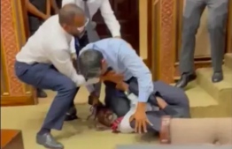 Easa has his knee on Shaheem's throat during the altercation in parliament yesterday.