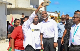 President Dr. Mohamed Muizzu takes a selfie with youths of Dhiyamigili during his tour of Thaa atoll.-- Photo: President's Office