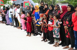 Thaa atoll Omadhoo residents line up to welcome President Muizzu during his visit to the island. -- Photo: President's Office