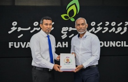 President Dr. Muizzu offering Fuvahmulah City Mayor, Ismail Rafeeq a book containing the president's speeches during the presidential campaign