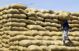 A labourer arranges sacks of grains at a market in Gedaref, eastern Sudan, on February 22, 2024. Ten months into a war that has sent Sudan to the "verge of collapse", the vast majority of its people are going hungry, the UN's World Food Programme said on February 21. Since last April, Sudan has been gripped by fighting between the regular army and the paramilitary Rapid Support Forces, which has killed thousands and created what the United Nations calls "the world's largest displacement crisis". -- Photo: Ebrahim Hamid / AFP.