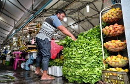 Activity at Local Market area: A person purchases lettuce from a market stall -- Photo: Nishan Ali
