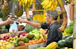 Activity at Local Market area: a person purchases fruits from a market stall -- Photo: Nishan Ali