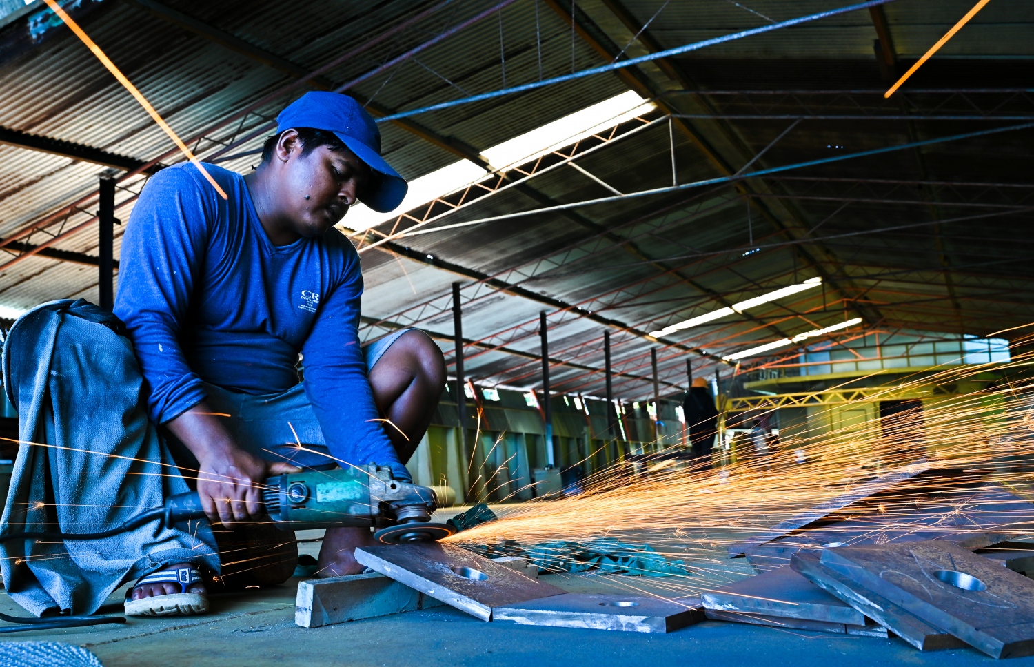 ތ. ވޭމަންޑޫ އަހްމަދު ނައީމް (ނައީމްބެ) ގެ މާވަޑިކަމުގައި ބަންނަމުން އަންނަ ބޮޑު ބޯޓުގައި ބިދޭސީ މަސައްކަތު މީހަކު ދަގަނޑު ގަނޑެއްގައި ގްރޭންޑަރު އަޅަނީ: އޭގައި މަސައްކަތްކުރާ މީހުން ބުނީ ގިނަ މަސައްކަތް ދަސްވީ ނައީމްބެގެ ފަރާތުން ކަމަށް. -- ފޮޓޯ: ފަޔާޒް މޫސާ/މިހާރު