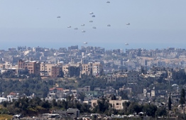 In this picture taken from Israel's southern border with the Gaza Strip shows humanitarian aid being airdropped over the Palestinian territory on March 12, 2024, amid the ongoing conflict between Israel and the militant group Hamas. (Photo by Menahem Kahana / AFP)