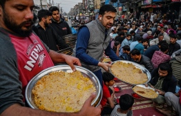 Volunteers distribute Iftar food into devotees before breaking their fast along a street on the first day of the holy month of Ramadan in Rawalpindi on March 12, 2024. --Photo: Aamir Qureshi / AFP