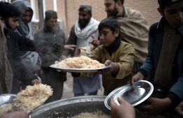 Loacal Afghan people distribute food to the Muslim devotees ahead of Iftar during the Islamic holy month of Ramadan at the Wazir Akbar Khan mosque in Kabul on March 12, 2024. -- Photo: Wakil Kohsar / AFP