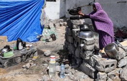 އިޒްރޭލުން ބިމާ ހަމަކޮށްލާފައިވާ އިމާރާތެއްގެ ކައިރީގައި ފަލަސްތީނު މީހަކު ތެލިތަށި ދޮންނަނީ. -- ފޮޓޯ: އޭއެފްޕީ