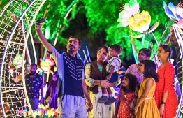 A family poses for a selfie near a crescent-shaped light fixture at the Republic Square. -- Photo: Fayaz Moosa / Mihaaru