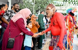 A 'Maali' shakes hands with a child in the audience.-- Photo: Nishan Ali / Mihaaru