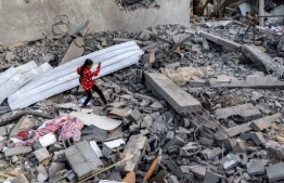 A girl walks through rubble in Rafah in the southern Gaza Strip on April 24, 2024 following reported Israeli air strikes overnight amid the ongoing conflict in the Palestinian territory between Israel and the militant group Hamas. -- Photo: Mohamed Abed / AFP