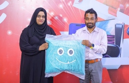 A lucky winner being handed their prize during the ceremony held by Ooredoo. -- Photo: Fayaz Moosa / Mihaaru News