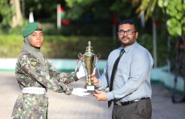 Defence Minister Ghassan presents trophy to Hamna, best all around in the 70th MNDF Basic Training Course.-- Photo: MNDF