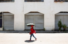 A woman shelters from the sun with an umbrella during hot weather in Manila on April 28, 2024. The Philippines will suspend in-person classes in all public schools for two days due to extreme heat and a nationwide strike by jeepney drivers, the education department said on April 28. -- Photo: Earvin Perias / AFP