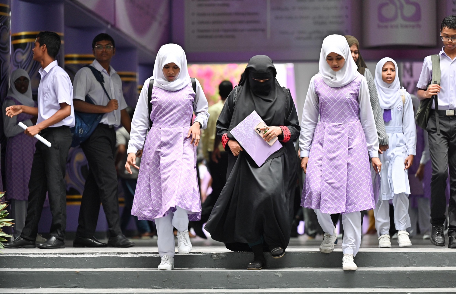 ސްކޫލު ކުދިންތަކެއް ރިޕޯޓް ފޯމް ހިފައިގެން ބެލެމިވެރިއަކާއެކު ދަނީ-- ފޮޓޯ: ނިޝާން އަލީ/ މިހާރު