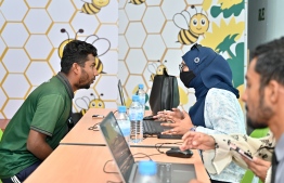 Immigrant workers employed in K. Himmafushi waiting at the counter to register their information after the campaign 'Kurangi' was launched nationwide to obtain fingerprint and photographs of immigrants. -- Photo: Nishan Ali / Mihaaru News