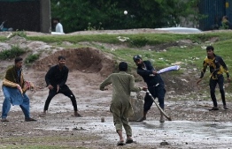 Local youths play cricket amid rainfall in Islamabad on April 29, 2024. (Photo by Aamir QURESHI / AFP)