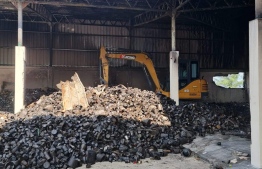 Clearing up the debris after the fire was put out.-- Photo: MNDF