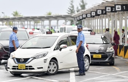 Police stationed nearby the taxi queue at the Velana International Airport in order to maintain disorder. -- Photo: Nishan Ali / Mihaaru News