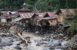 Damaged houses are seen after flash floods and cold lava flow from a volcano in Tanah Datar, West Sumatra, on May 12, 2024. At least 34 people have died and 16 more were missing after flash floods and cold lava flow from a volcano hit western Indonesia, a local disaster official said on May 12. -- Photo: Rezan Soleh / AFP