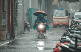 Motorist on flooding streets of Male' as the heavy rain continues.-- Photo: Nishan Ali / Mihaaru