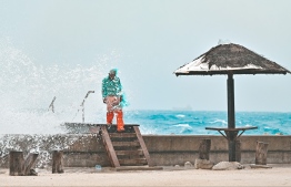 A man near the sea at Rasfannu Beach, getting caught in the salt spray from strong waves.-- Photo: Nishan Ali / Mihaaru