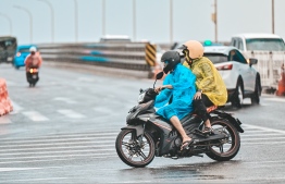 Two people cross the Sinamale' Bridge and arrive in Male'. Police has cautioned those travelling on the bridge to take precautions and be alert of the rough weather conditions.-- Photo: Fayaz Moosa / Mihaaru