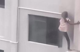 Screengrab from video showing the child climbing in from the window in the stairwell.