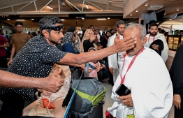 A pilgrim of the first Maldivian Hajj group spending some time with his family at the Velana International Airport (VIA) on Friday before his departure to Saudi Arabia for Hajj. -- Photo: Nishan Ali / Mihaaru News
