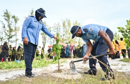 Two police officers planting treees during the tree plantation activity held by SIMDI group at Hulhumale, Phase 2. -- Photo: Fayaz Moosa / Mihaaru News
