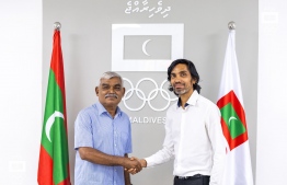 Olympics Committee President Mohamed Abdul Sattar (left) shakes hands with TTAM President Ali Rasheed (right) during the ceremony to appoint Ali as the Maldives Chef de Mission for the Olympics -- Photo: MOC.