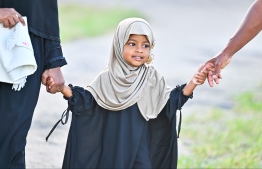 A little girl heading to the B.Kendhoo football stadium to join the Eid-al-Adha prayer congregation with her parents today. -- Photo: Fayaz Moosa / Mihaaru News