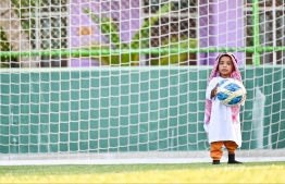 A toddler standing with a ball in front of a goalpost in Baa atoll Kendhoo's football stadium after Eid-al-Adha prayers. -- Photo: Fayaz Moosa / Mihaaru News