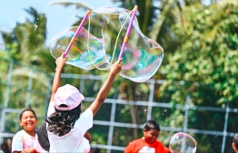 A little girl blowing bubbles at the Bubble Show held in Baa Kendhoo Volleyball Court. -- Photo: Fayaz Moosa / Mihaaru News