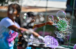 Children blowing bubbles at the Bubble Show held for children in Baa Kendhoo Volleyball Court to colorfully celebrate Eid-al-Adha festivities. -- Photo: Fayaz Moosa / Mihaaru News