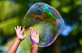 A child attempting to pop a bubble during the Bubble Show held for children in Baa Kendhoo Volleyball Court to colorfully celebrate Eid-al-Adha festivities. -- Photo: Fayaz Moosa / Mihaaru News