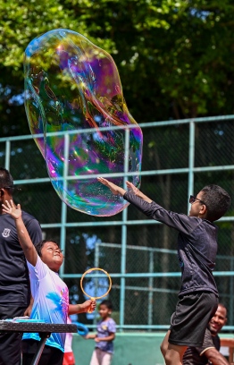 Children attempting to pop a bubble during the Bubble Show held for children in Baa Kendhoo Volleyball Court to colorfully celebrate Eid-al-Adha festivities. -- Photo: Fayaz Moosa / Mihaaru News