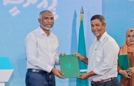 Former Maldivian Democratic Party (MDP) member and (current) Parliamentarian of the Vaikaradhoo Constituency, Mohamed Nazim handing over his registration form to President Muizzu after signing into People's National Congress (PNC). -- Photo: PNC